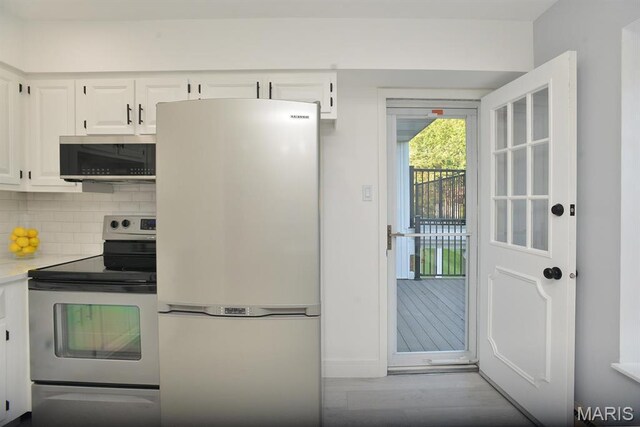 1680 Herault Pl Unit F, Saint Louis, MO 63125 - kitchen with appliances with stainless steel finishes, light countertops, white cabinetry, wood finished floors, and tasteful backsplash