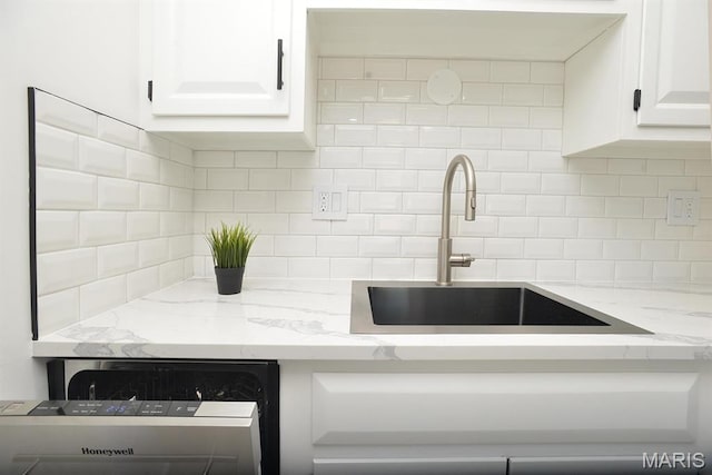 1680 Herault Pl Unit F, Saint Louis, MO 63125 - kitchen featuring a sink, dishwashing machine, backsplash, and white cabinets