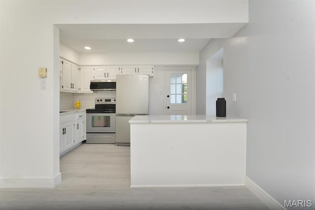 1680 Herault Pl Unit F, Saint Louis, MO 63125 - kitchen with appliances with stainless steel finishes, light wood-style floors, light countertops, decorative backsplash, and a peninsula
