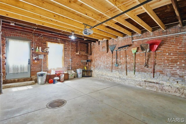 basement featuring brick wall and a garage