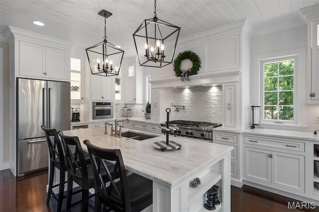 1178 Turnberry Dr, Innsbrook, MO 63390 - kitchen with stainless steel appliances, a sink, white cabinetry, a chandelier, and dark wood finished floors