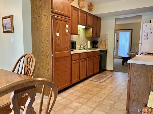 2128 Friendship Ct, Florissant, MO 63031 - kitchen featuring freestanding refrigerator, light floors, brown cabinetry, dishwasher, and light countertops