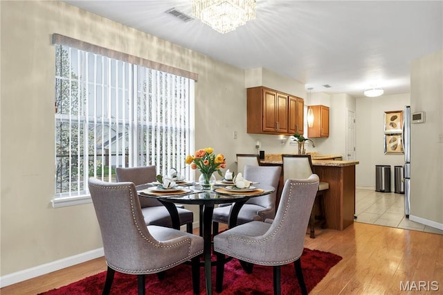 3110 Autumn Shores Dr, Maryland Heights, MO 63043 - dining space with healthy amount of natural light, a chandelier, and light wood-style floors