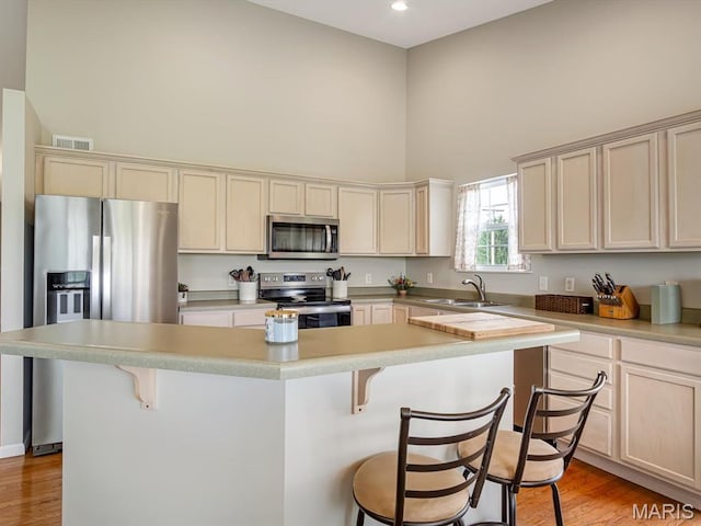 508 Southview Dr, Waterloo, IL 62298 - kitchen with appliances with stainless steel finishes, a towering ceiling, a sink, a breakfast bar area, and a kitchen island