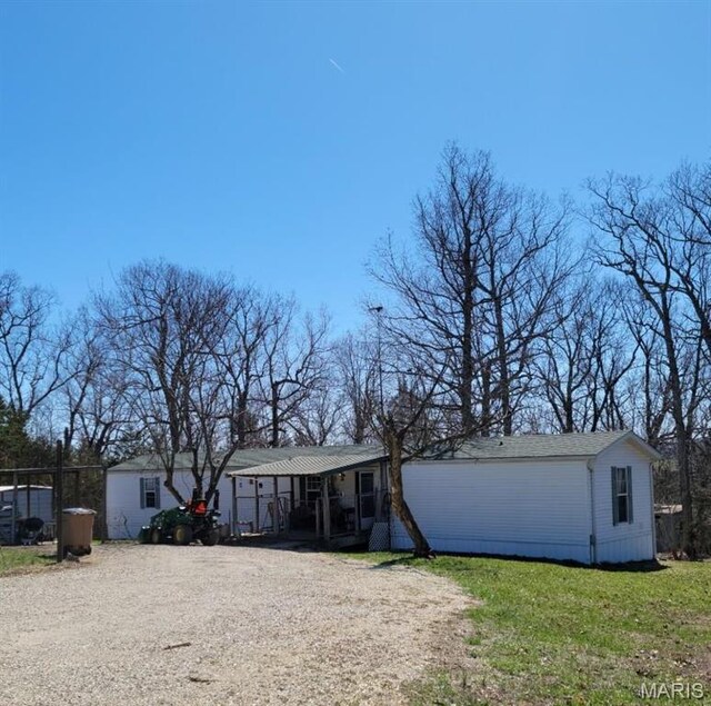 8336 Cedar Fork Rd, New Haven, MO 63068 - manufactured / mobile home featuring a porch, gravel driveway, and a front lawn