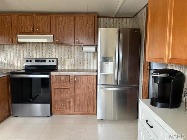 8336 Cedar Fork Rd, New Haven, MO 63068 - kitchen featuring appliances with stainless steel finishes, under cabinet range hood, wallpapered walls, brown cabinets, and light countertops