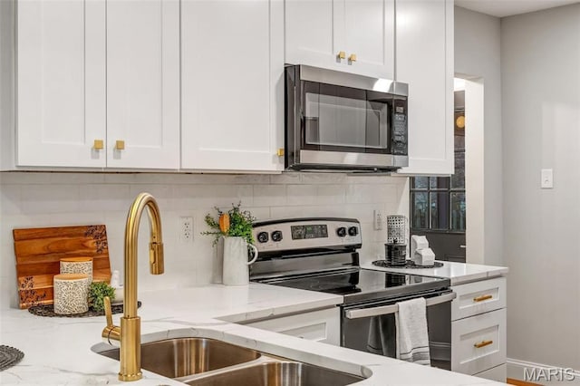 83 Chafford Woods, Saint Louis, MO 63144 - kitchen with stainless steel appliances, white cabinetry, decorative backsplash, and light stone counters