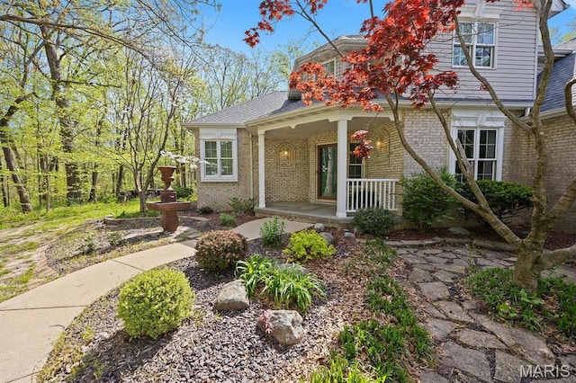 view of front of house with covered porch and brick siding