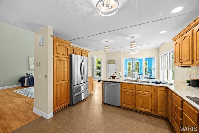 kitchen featuring stainless steel appliances, a sink, plenty of natural light, a peninsula, and recessed lighting