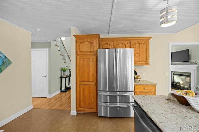 kitchen with appliances with stainless steel finishes, dark wood-style flooring, baseboards, light stone counters, and brown cabinets
