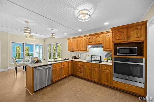 kitchen with stainless steel appliances, under cabinet range hood, a peninsula, backsplash, and light countertops