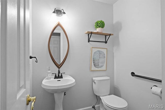 bathroom featuring toilet and baseboards