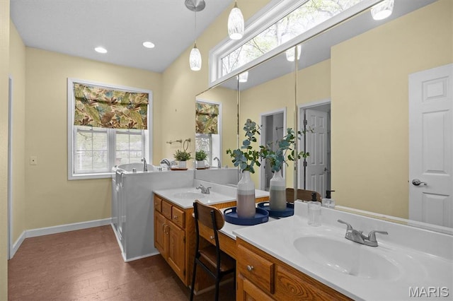 full bathroom featuring baseboards, healthy amount of natural light, double vanity, and recessed lighting
