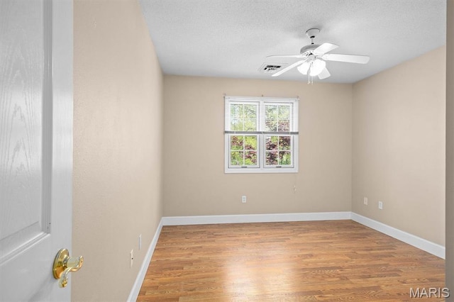 unfurnished room featuring light wood-style flooring, a textured ceiling, baseboards, and a ceiling fan