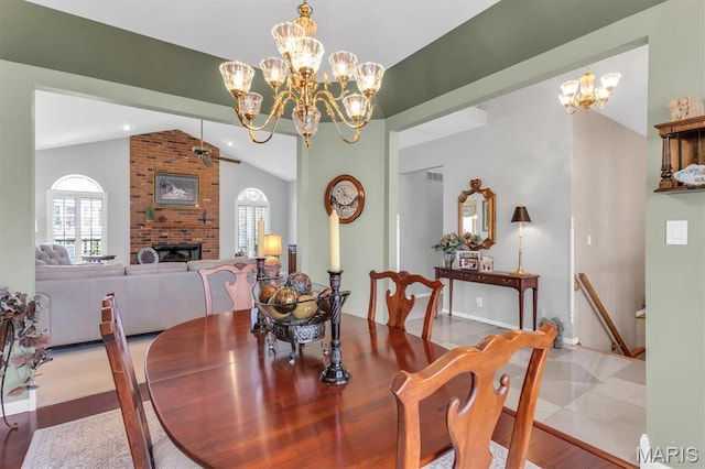13463 Keller Ridge Cv, Saint Louis, MO 63128 - tiled dining space featuring lofted ceiling, a fireplace, a chandelier, ceiling fan, and baseboards