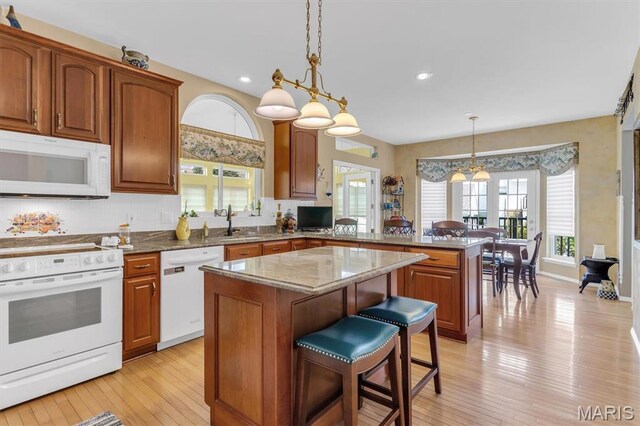 13463 Keller Ridge Cv, Saint Louis, MO 63128 - kitchen with white appliances, a peninsula, a center island, plenty of natural light, and recessed lighting