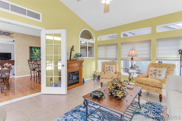 13463 Keller Ridge Cv, Saint Louis, MO 63128 - tiled living room featuring ceiling fan, high vaulted ceiling, baseboards, french doors, and a glass covered fireplace