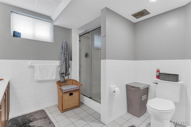 13463 Keller Ridge Cv, Saint Louis, MO 63128 - full bathroom featuring tile walls, a shower stall, tile patterned floors, toilet, and wainscoting