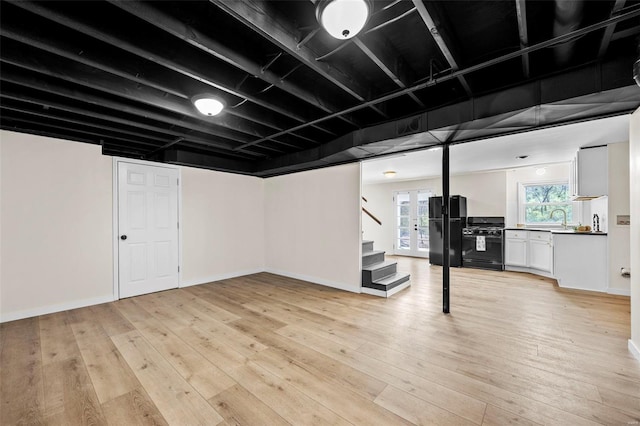 1300 Hudson Rd, Saint Louis, MO 63135 - below grade area featuring freestanding refrigerator, stairs, light wood finished floors, and a sink