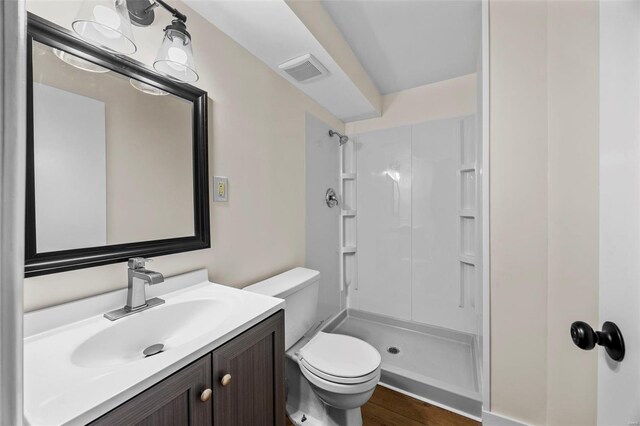 1300 Hudson Rd, Saint Louis, MO 63135 - bathroom with toilet, a shower stall, vanity, and wood finished floors