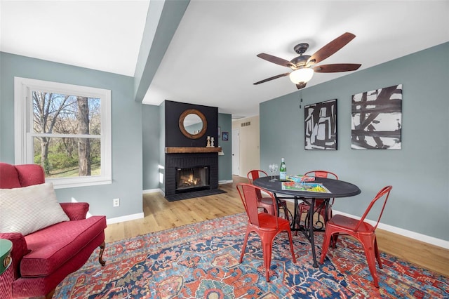 1300 Hudson Rd, Saint Louis, MO 63135 - dining room featuring wood finished floors, ceiling fan, a fireplace, and baseboards