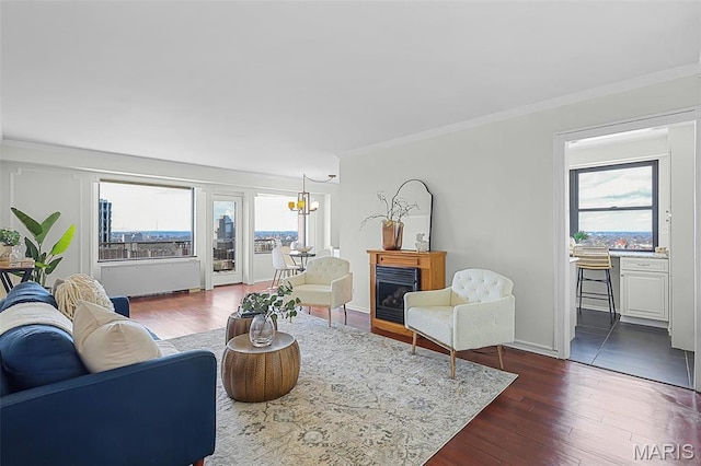4466 W Pine Blvd Unit 23C, Saint Louis, MO 63108 - living room featuring healthy amount of natural light, crown molding, dark wood-style flooring, a fireplace, and a chandelier