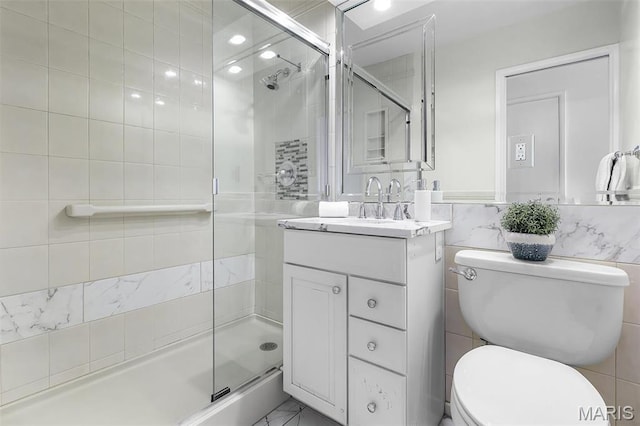 4466 W Pine Blvd Unit 23C, Saint Louis, MO 63108 - bathroom with tile walls, toilet, a stall shower, vanity, and marble finish floors