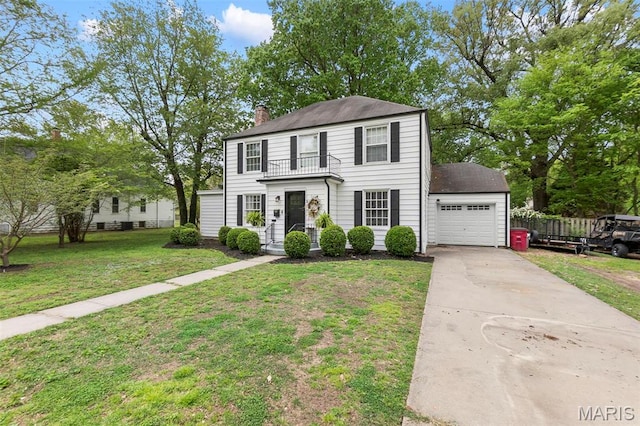 colonial-style house featuring a balcony, a chimney, concrete driveway, and a garage