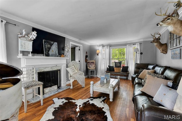 living area featuring hardwood / wood-style flooring, ornamental molding, and a premium fireplace
