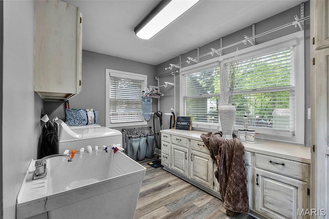 clothes washing area featuring light wood-style floors and washer / clothes dryer