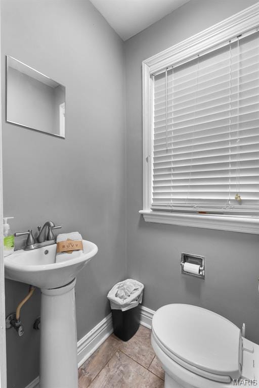 bathroom featuring baseboards and toilet