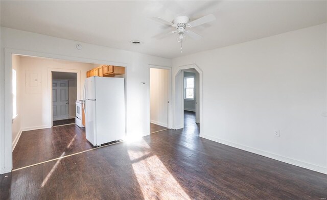 223 Warren St, Sullivan, MO 63080 - unfurnished living room featuring dark wood-type flooring, baseboards, ceiling fan, and arched walkways