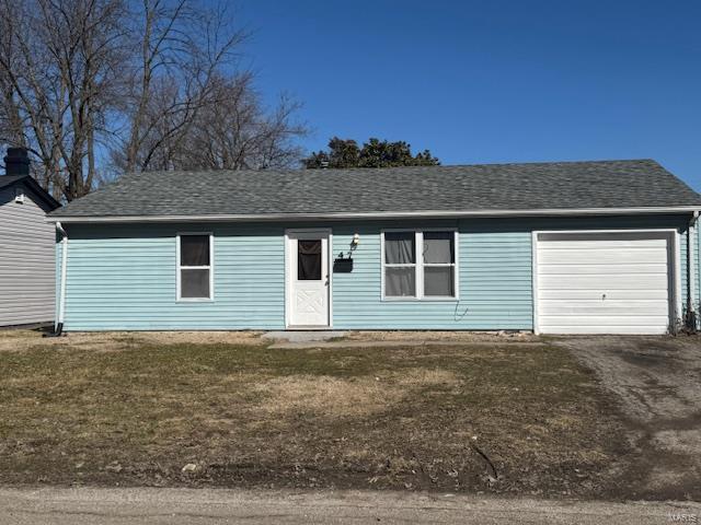 ranch-style home with a shingled roof, driveway, a front yard, and a garage
