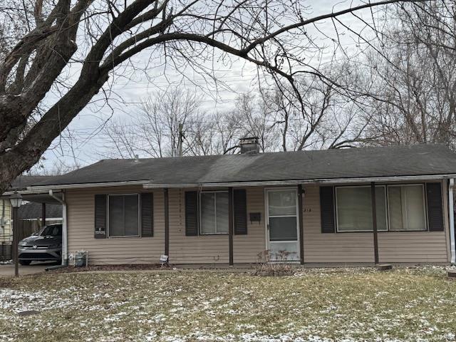 single story home featuring a chimney and a carport