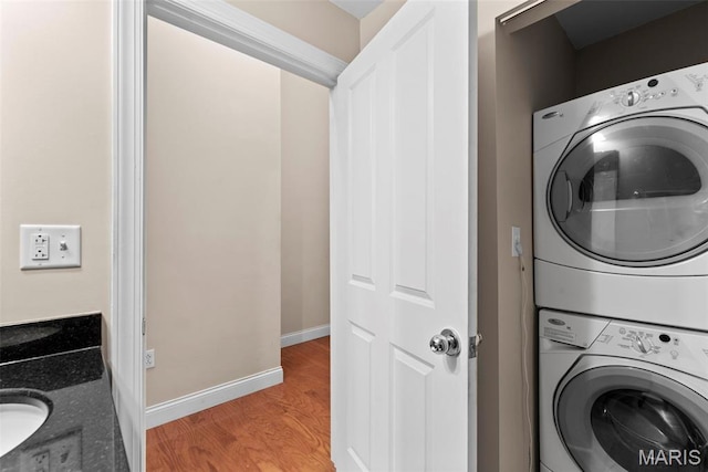 1515 Lafayette Ave Unit 316, Saint Louis, MO 63104 - laundry area with stacked washing machine and dryer, light wood finished floors, and baseboards
