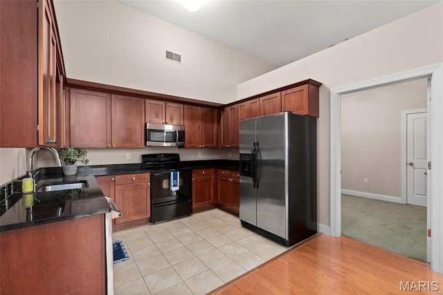 1515 Lafayette Ave Unit 316, Saint Louis, MO 63104 - kitchen featuring stainless steel appliances, a sink, dark stone counters, and baseboards