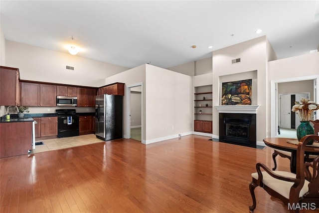 1515 Lafayette Ave Unit 316, Saint Louis, MO 63104 - kitchen with appliances with stainless steel finishes, open floor plan, built in features, dark countertops, and light wood-style flooring
