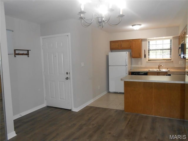 12954 Bryce Canyon Dr Unit E, Maryland Heights, MO 63043 - kitchen with freestanding refrigerator, black microwave, brown cabinets, a chandelier, and light countertops