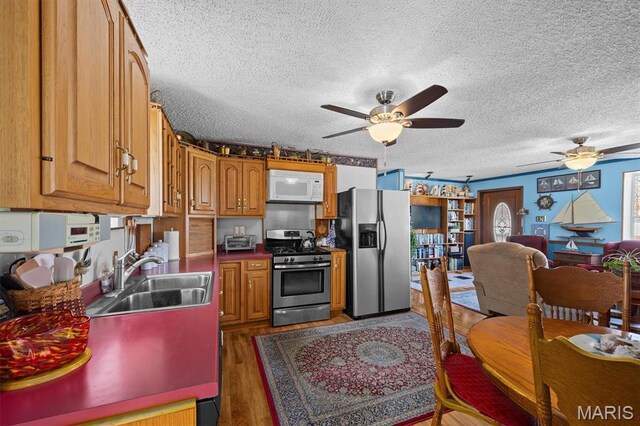 10 Mallard Dr, Carlyle, IL 62231 - kitchen with stainless steel appliances, a sink, ceiling fan, wood finished floors, and a textured ceiling