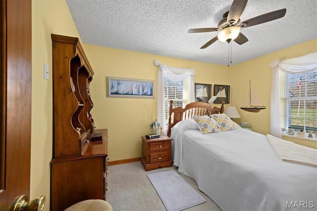 10 Mallard Dr, Carlyle, IL 62231 - bedroom with multiple windows, a textured ceiling, carpet flooring, ceiling fan, and baseboards