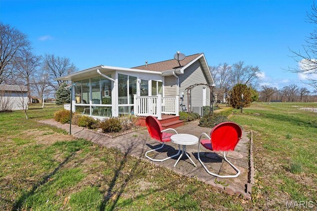 10 Mallard Dr, Carlyle, IL 62231 - rear view of house featuring a sunroom and a lawn