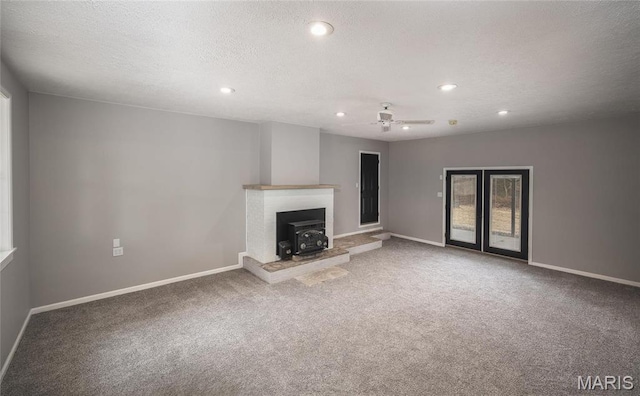 12000 State Rte E, Rolla, MO 65401 - unfurnished living room with carpet floors, recessed lighting, a wood stove, a ceiling fan, and a textured ceiling