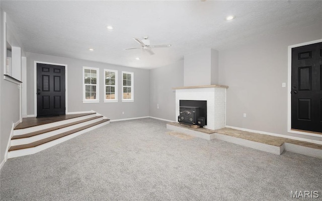 12000 State Rte E, Rolla, MO 65401 - unfurnished living room featuring ceiling fan, carpet floors, a wood stove, and recessed lighting