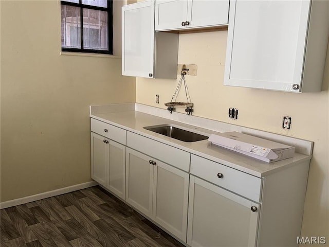 1519 Mallinckrodt St, Saint Louis, MO 63107 - kitchen featuring a sink, light countertops, baseboards, and white cabinets