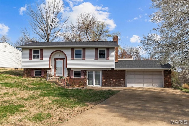 953 E 1st St, Washington, MO 63090 - bi-level home with a chimney, a garage, driveway, a front yard, and brick siding