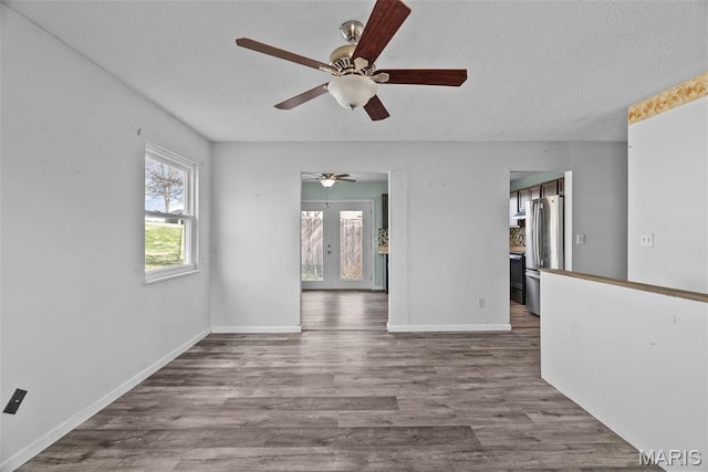 953 E 1st St, Washington, MO 63090 - empty room featuring french doors, a ceiling fan, wood finished floors, baseboards, and a textured ceiling
