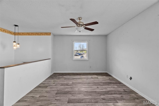 953 E 1st St, Washington, MO 63090 - empty room featuring a ceiling fan, wood finished floors, a textured ceiling, and baseboards
