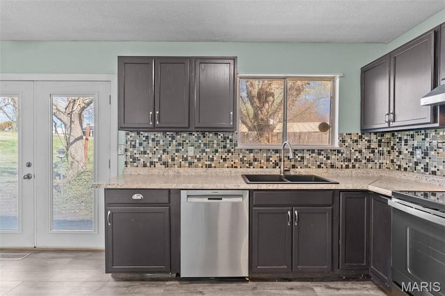 953 E 1st St, Washington, MO 63090 - kitchen with appliances with stainless steel finishes, a sink, backsplash, light countertops, and light wood-style floors