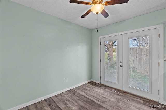 953 E 1st St, Washington, MO 63090 - spare room featuring a textured ceiling, wood finished floors, baseboards, french doors, and ceiling fan