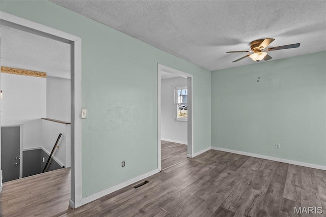 953 E 1st St, Washington, MO 63090 - spare room featuring a textured ceiling, wood finished floors, a ceiling fan, and baseboards